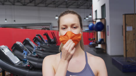 Fit-caucasian-woman-wearing-face-mask-in-the-gym