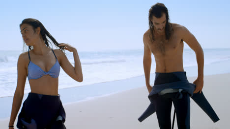 Surfer-couple-changing-their-wetsuits-4k