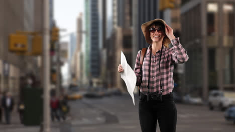 Mujer-Caucásica-Turista-En-Una-Calle-Con-Gafas-De-Sol-Y-Un-Sombrero,-Sosteniendo-Un-Mapa
