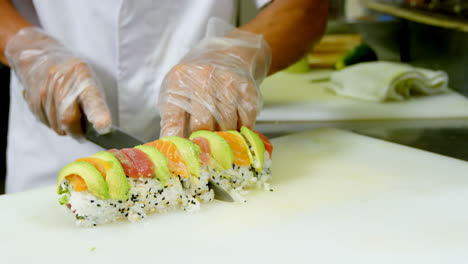 Male-chef-cutting-sushi-in-kitchen-4k