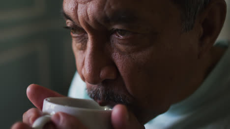 Close-up-of-senior-mixed-race-man-drinking-coffee