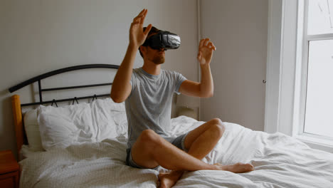 Man-using-virtual-reality-headset-on-bed-in-bedroom-4k