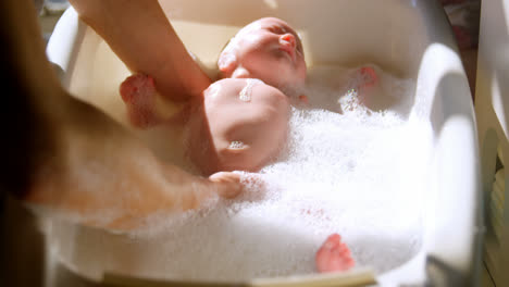Mother-giving-her-baby-boy-a-bath-in-bathroom-4k