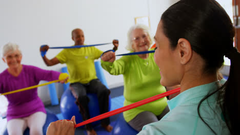 Rückansicht-Einer-Trainerin,-Die-ältere-Menschen-Beim-Training-Im-Fitnessstudio-Trainiert,-4k