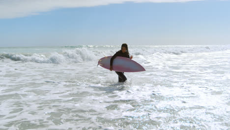 Mujer-Con-Tabla-De-Surf-Corriendo-En-El-Mar-4k