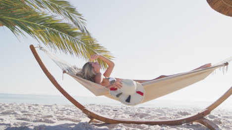 Caucasian-woman-lying-on-a-hammock-on-the-beach