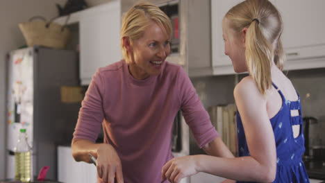 Side-view-of-Caucasian-woman-with-her-daughter-in-the-kitchen