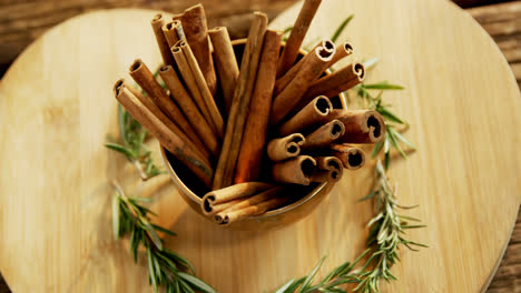 Cinnamon-sticks-and-rosemary-arranged-on-wooden-board-4k