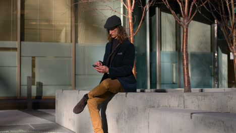Side-view-of-young-Caucasian-man-using-mobile-phone-in-city-4k