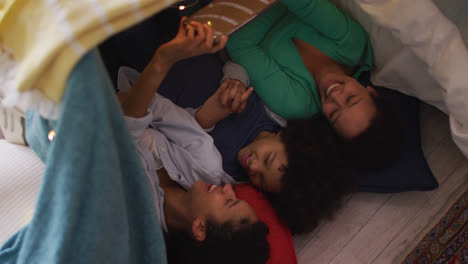 Lesbisches-Paar-Gemischter-Abstammung-Und-Tochter-Benutzen-Smartphone-Im-Schlafzimmerlager