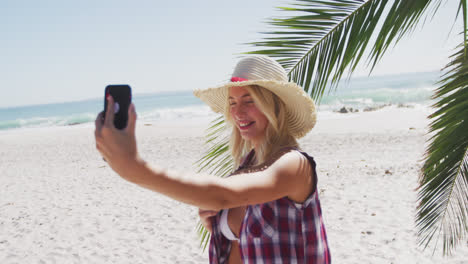 Portrait-of-a-Caucasian-woman-taking-a-selfie-on-the-beach