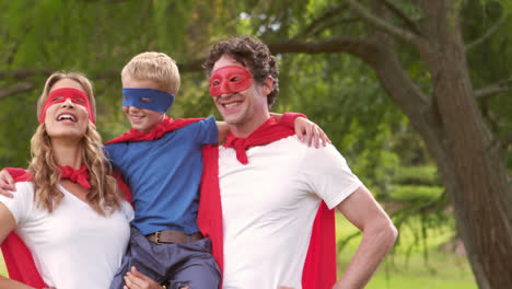 Boom-text-on-speech-bubbles-against-mother-and-dad-carrying-their-son-in-superhero-costume