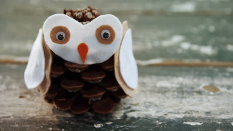 Pine-cone-owl-on-wooden-table-4k