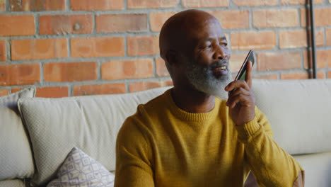 Senior-man-talking-on-mobile-phone-in-living-room-4k