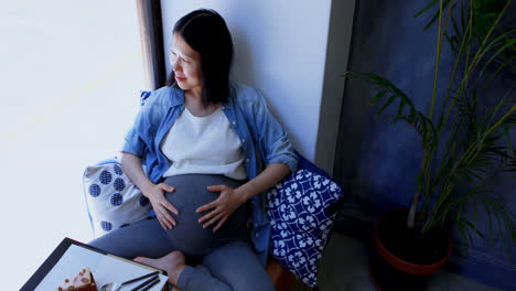 Pregnant-woman-looking-through-window-4k