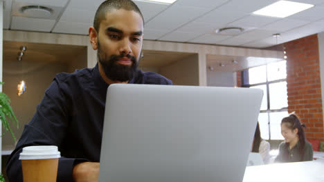 Ejecutivo-Masculino-Usando-Laptop-En-La-Cafetería-De-La-Oficina-4k