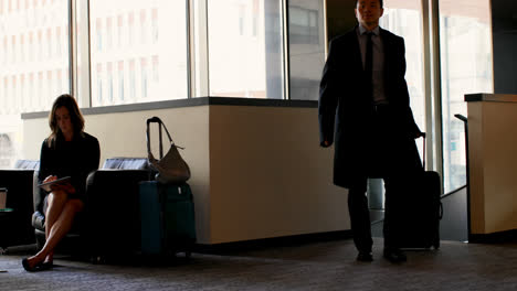Asian-businessman-walking-with-luggage-in-a-hotel-lobby-4k