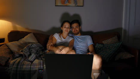 Couple-watching-movie-on-laptop-at-home-4k