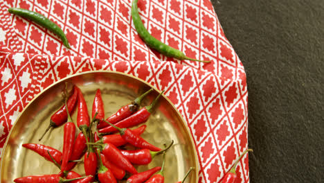 Red-chilies-in-plate-on-table-cloth-4k