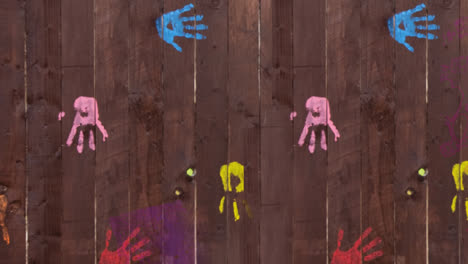 Pink-paint-covering-handprints-on-wooden-boards