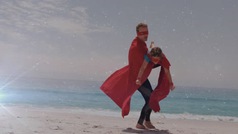 Glowing-spot-of-light-against-father-and-son-in-superhero-costume-on-a-beach