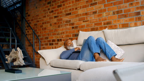 Senior-man-using-laptop-in-living-room-4k
