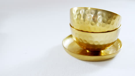 Golden-steel-bowls-and-plate-on-white-background-4k