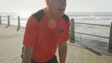 Senior-man-taking-a-break-from-running-on-the-promenade