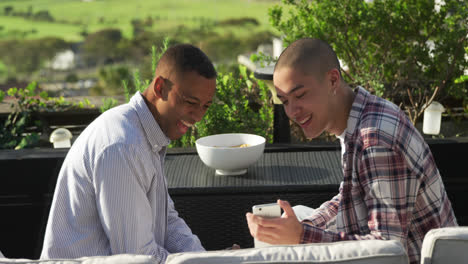 Friends-discussing-and-using-a-smartphone-on-a-rooftop