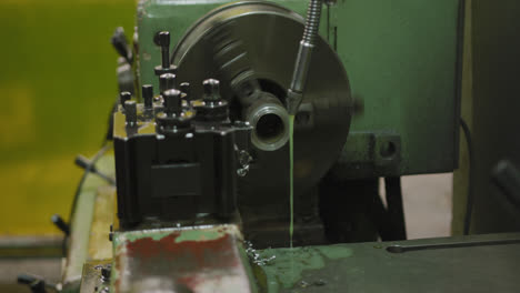 Piece-of-machinery-in-the-workshop-at-a-factory-turning-and-cutting-a-piece-of-metal-pipe