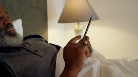 Senior-man-using-mobile-phone-in-bedroom-4k