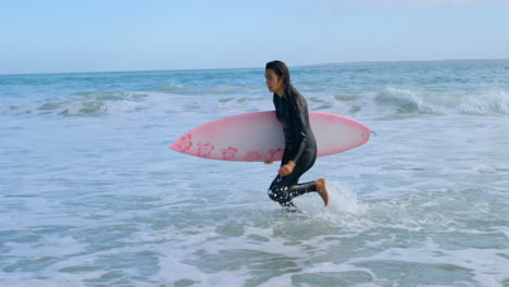 Surfista-Femenina-Con-Tabla-De-Surf-Corriendo-Hacia-La-Costa-4k