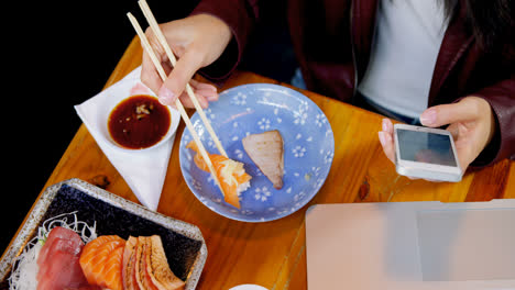Frau,-Die-Sushi-Isst,-Während-Sie-Ihr-Mobiltelefon-Im-Restaurant-4k-Benutzt