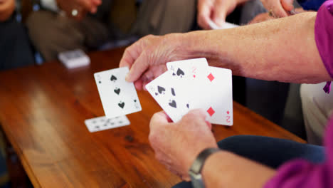 Mid-section-of-senior-people-playing-cards-at-nursing-home-4k