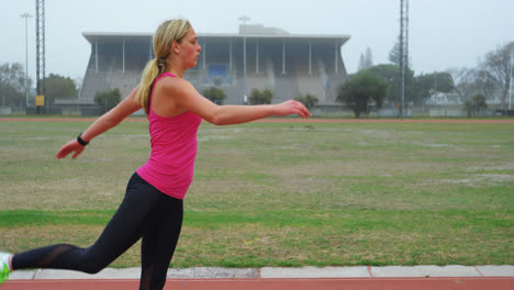 Side-view-of-Caucasian-female-athlete-exercising-on-running-track-4k