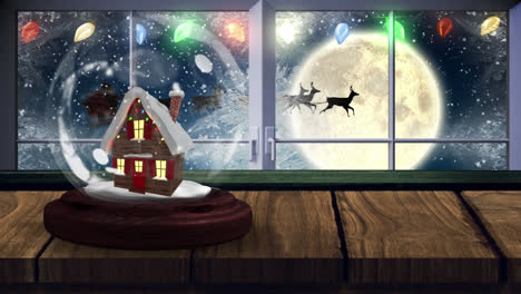 Animation-of-two-snow-globe-with-house-with-winter-scenery-and-full-moon-seen-through-window-in-the