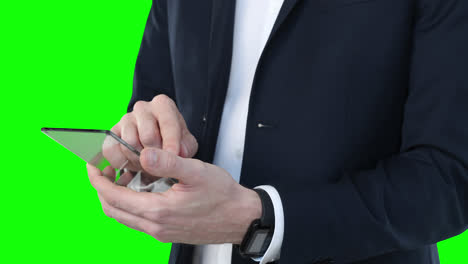 Mid-section-of-a-Caucasian-man-holding-a-transparent-screen-on-green-background