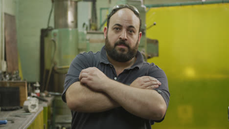 Caucasian-male-factory-worker-at-a-factory-standing-with-arms-crossed-looking-to-the-camera