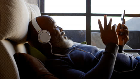 Senior-man-using-mobile-phone-in-living-room-4k