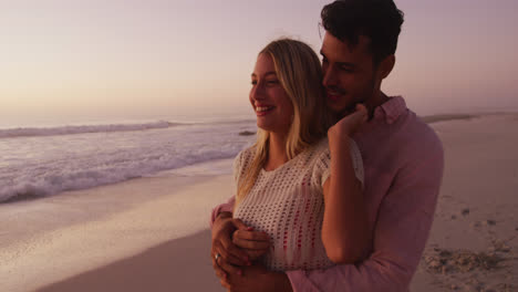 Caucasian-couple-enjoying-time-at-the-beach-during-the-sunset