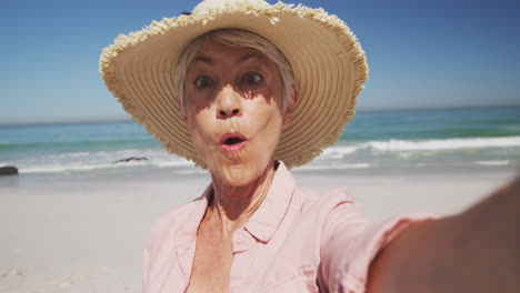 Mujer-Caucásica-Mayor-Disfrutando-Del-Tiempo-En-La-Playa-Con-El-Mar-Al-Fondo