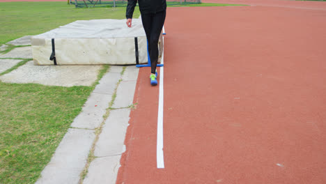 Low-section-of-female-athlete-measuring-high-jump-field-with-footstep-4k
