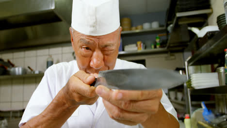 Chef-Masculino-Mirando-Un-Cuchillo-En-La-Cocina-4k