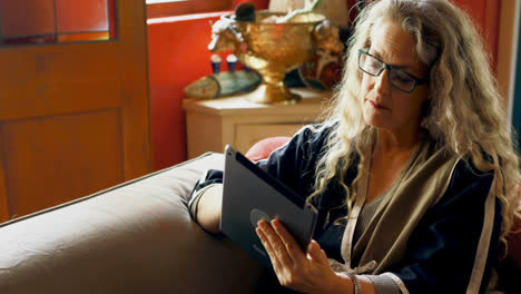 Mature-woman-using-digital-tablet-in-living-room-4k