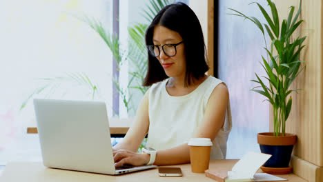 Female-executive-using-laptop-at-desk-4k