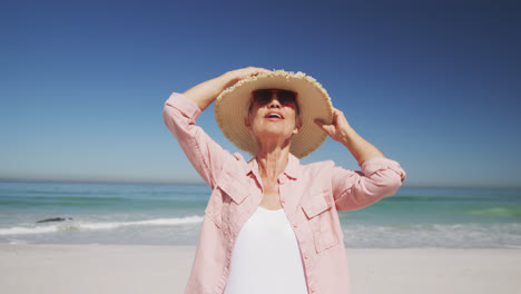 Senior-Caucasian-woman-enjoying-time-at-the-beach-with-sea-in-the-background