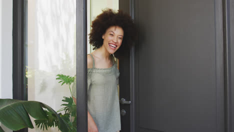 Mixed-race-woman-opening-a-entrance-door-and-looking-at-camera