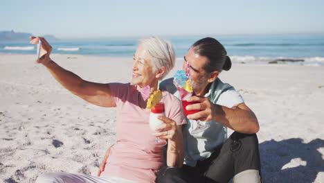 Senior-Caucasian-couple-taking-a-selfie-at-the-beach