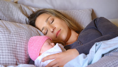Mother-sleeping-with-her-baby-boy-in-bedroom-4k