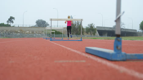 Rear-view-of-female-athlete-jogging-on-a-running-track-at-sports-venue-4k